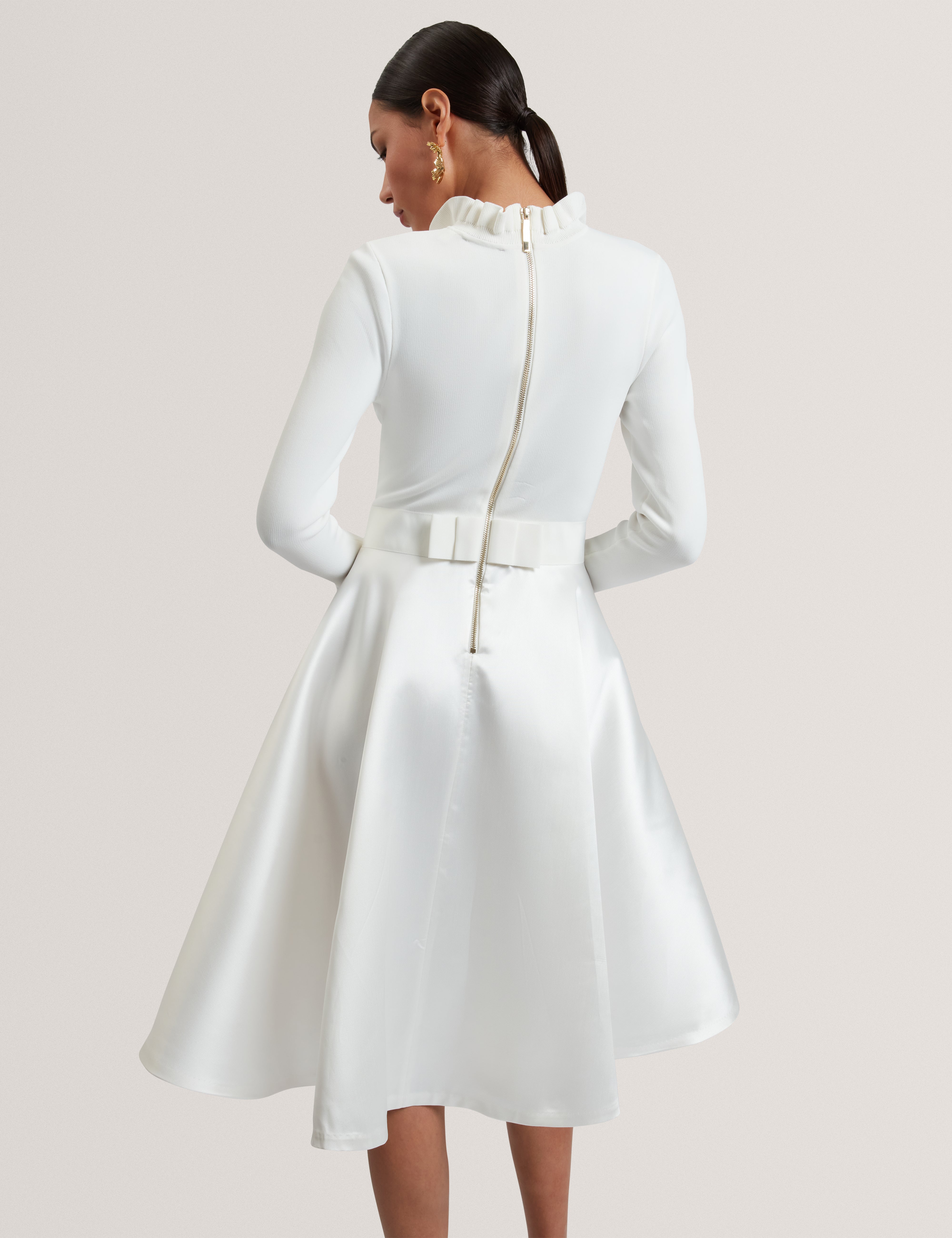 فستان زادي منسوج بأطراف مكشكشة، يبلغ طوله كامل، باللون العاجي.