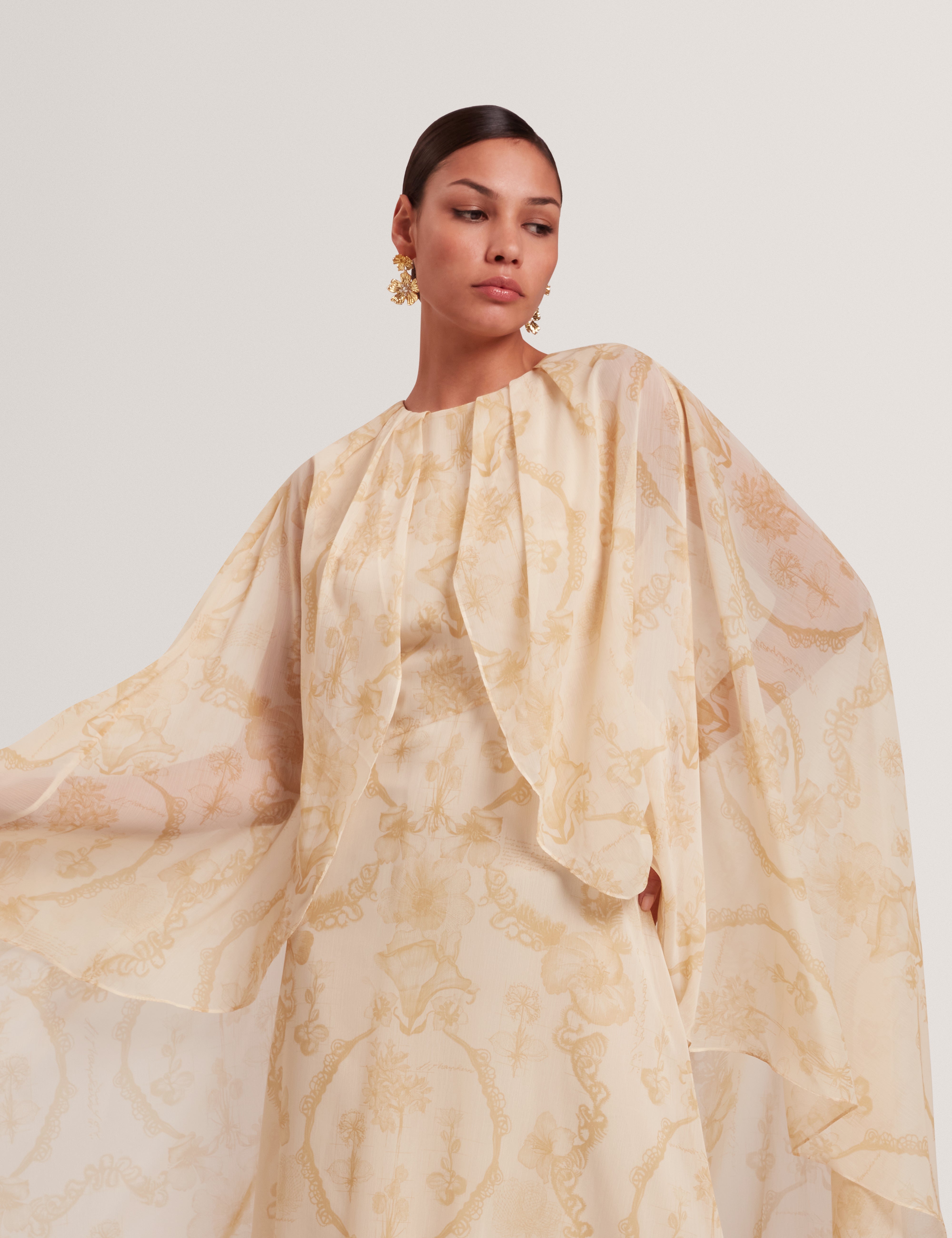 فستان ماكسي نييفا ذو التفاصيل الشلالية مع كيب، لون أصفر فاتح.