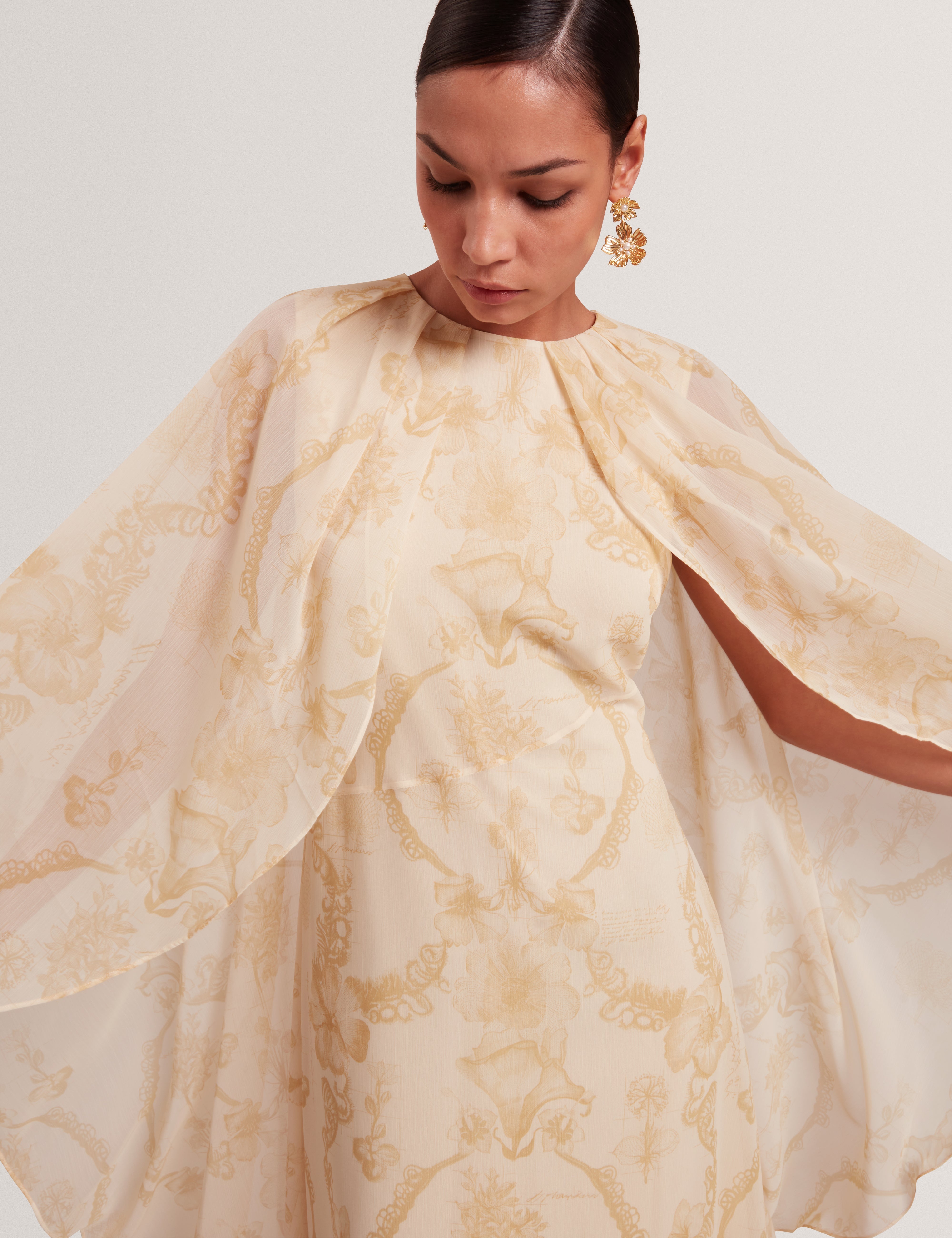 فستان ماكسي نييفا ذو التفاصيل الشلالية مع كيب، لون أصفر فاتح.