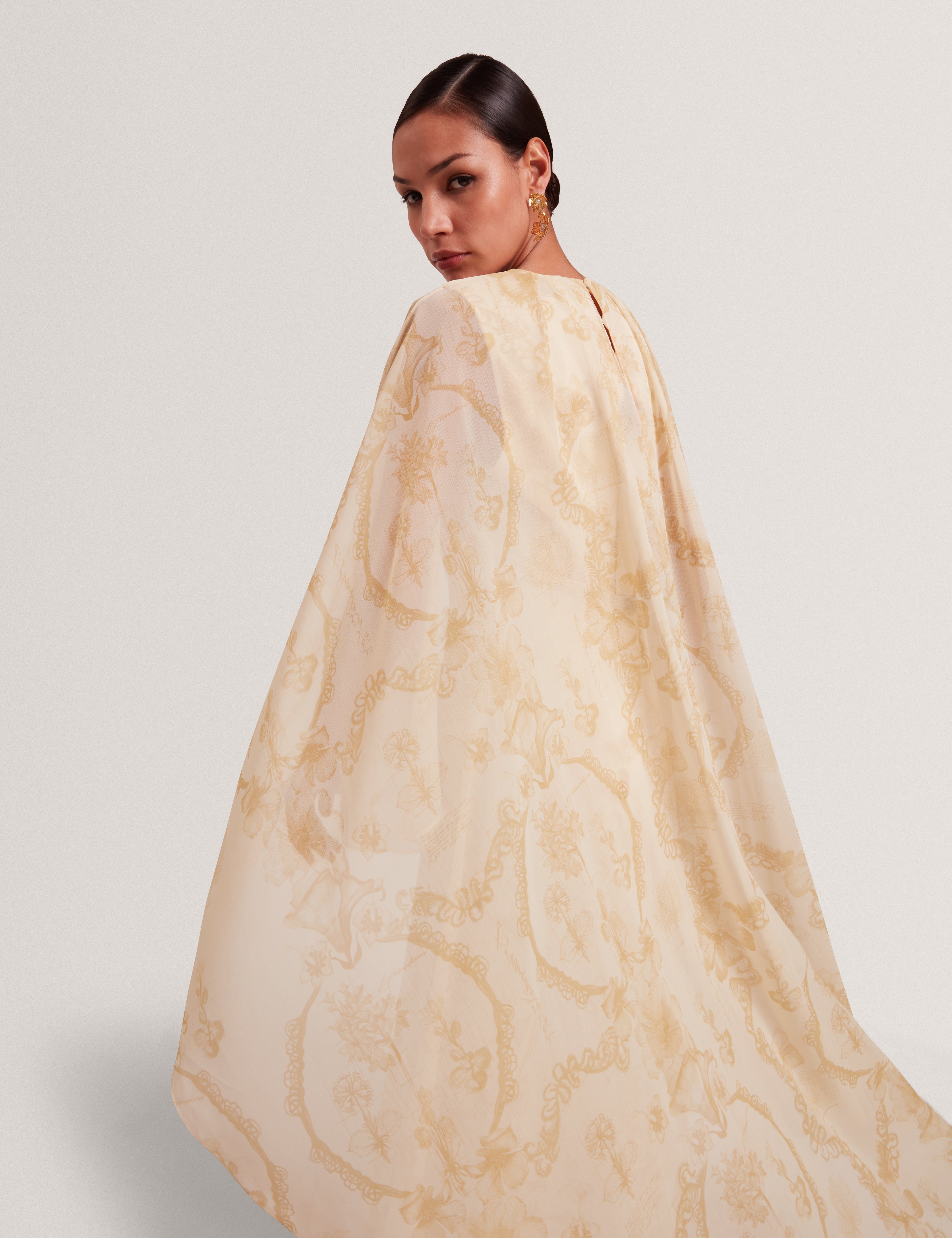 فستان ماكسي نييفا ذو التفاصيل الشلالية مع كيب، لون أصفر فاتح.